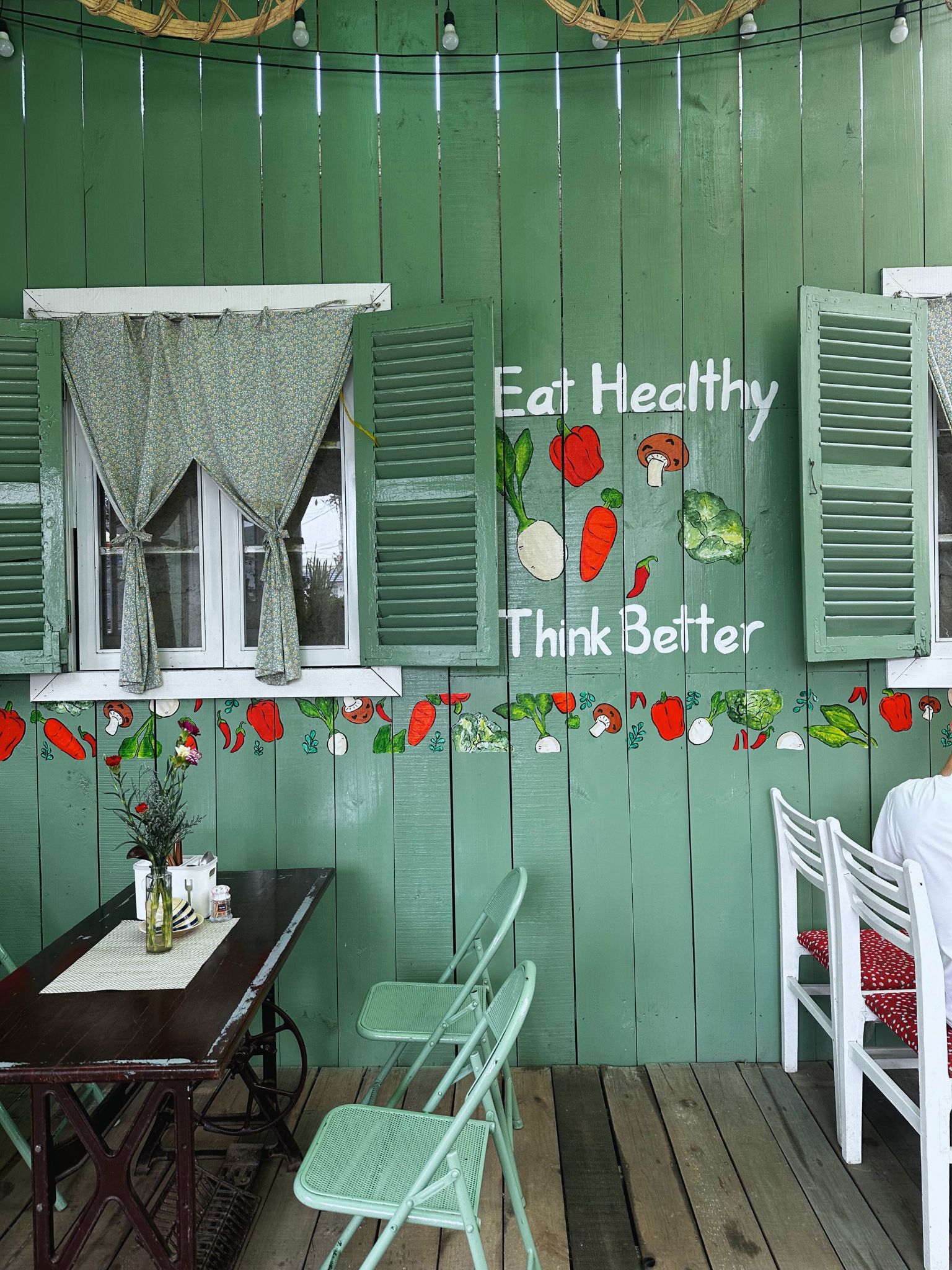 A green wall stating Eat Healthy Think better in a restaurant